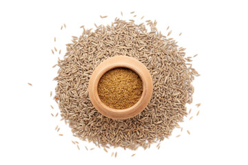 A mud pot filled with organic Cumin Seeds (Cuminum cyminum) or jeera powder, placed over a heap of whole Cumin Seeds, isolated on a white background.