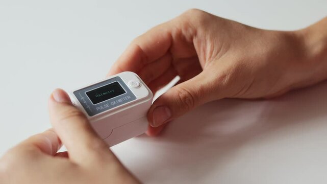 Adult patient checking heart rate and oxygen levels with advanced technology using fingertip oximetry applying electronic oximeter to monitor blood saturation and cardiac health