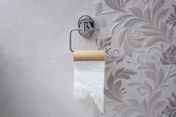 Empty toilet roll holder in home toilet, close-up.