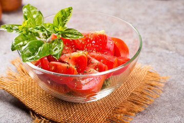 Tomato salad with fresh basil dressed with olive oil.
