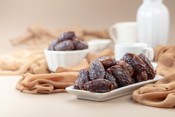Dates in white dish on a beige background.