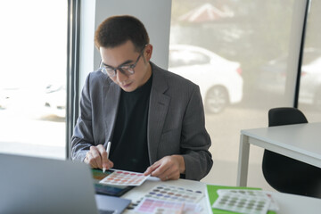 Fototapeta premium Business asian Man Artist Creative Designer sketch graphic drawing on graphic laptop and Color swatch samples Concept of idea creativity