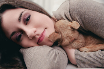 Puppy sleeps soundly in woman's gentle embrace
