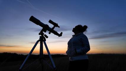 Amateur astronomer looking at the evening skies, observing planets, stars, Moon and other celestial...
