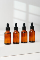 Collection of Amber Glass Dropper Bottles Displayed on a Minimalist White Surface in Natural Light