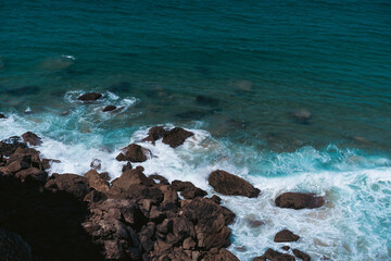 Aerial view of waves crashing on rocky shore