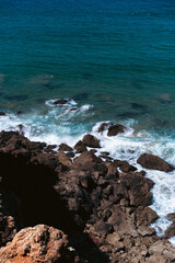 Ocean waves crash against the rocky shore.