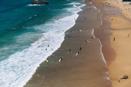 Surfers on the waves at Praia do Tonel in Sagres, Algarve, Portugal.