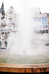 Hot spring water fountain in front of buildings in karlovy vary