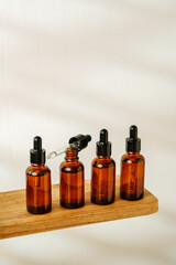 Collection of Amber Glass Bottles and Jars for Essential Oils on a White Surface