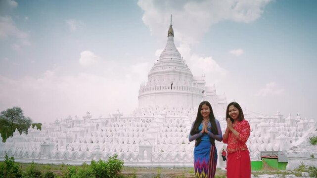 Pretty woman in treaditional suite holding violet paper umbrella travel and make a merit at Hsinbyume Pagoda in Mingun Mandaley, Myanmar.