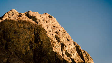 high rocky mountain against a clear blue sky