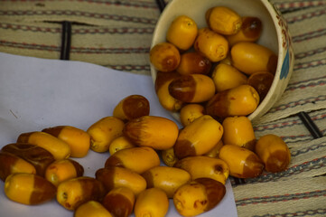 Dates yellow fruit in dish cup on wood paper