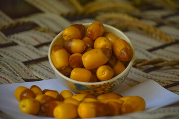 sweet fruit dates in a white bowl on a wooden table