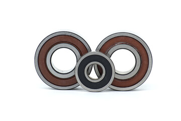Close-up of three metal ball bearings of different sizes isolated on a white background