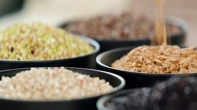 A variety of different colored Raw healthy grain food, Various grains, cereals, beans, legumes are rotated in wooden decoration for advertisement concept. High protein products, Healthy vegan food.