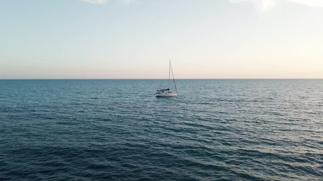 Circling around a sailboat on a beautiful blue sea during a summer evening on the Italian coastline.