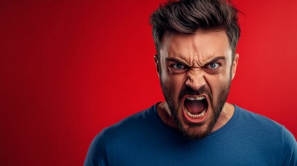 Obraz premium Man displays a fierce and intense expression of anger on red backdrop