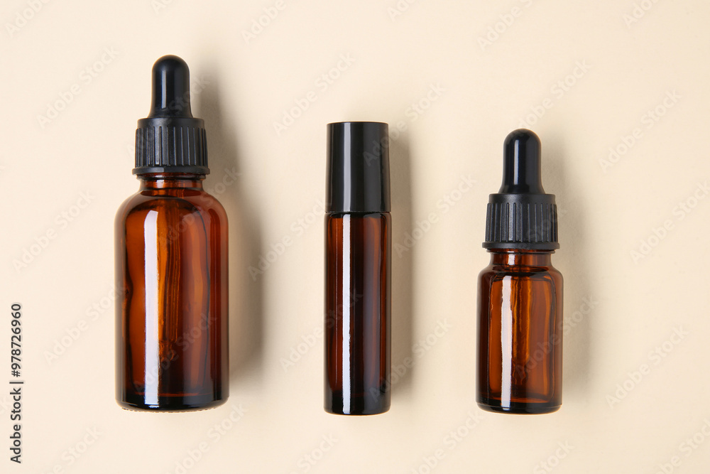 Wall mural Essential oils in bottles on beige background, flat lay