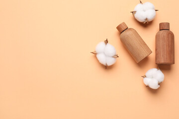 Different cosmetic products and cotton flowers on pale orange background, flat lay. Space for text