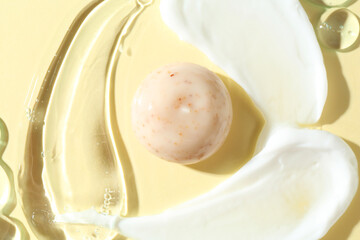 Smears of different cosmetic products on beige background, top view