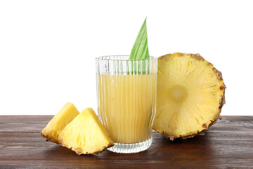 Glass with pineapple juice and pieces of fresh fruit on wooden table against white background