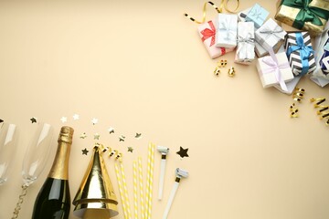 Flat lay composition with confetti and bottle of sparkling wine on beige background, space for text. Christmas decor