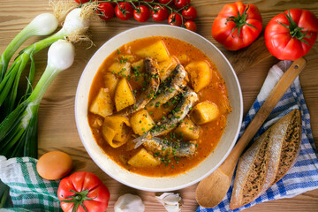 Sardine stew with potatoes and leeks. Top view table with  decorations.