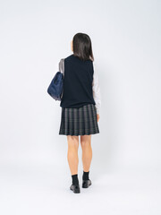制服を着て歩く女子学生の後ろ姿の全身写真
