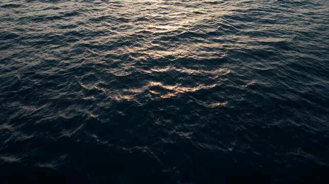 Upward panning shot of the darkening sea against an Italian sunset off the coast of Rome.