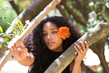 portrait of a beautiful young Latin woman with large, dark eyes and curly hair. The girl wears an...