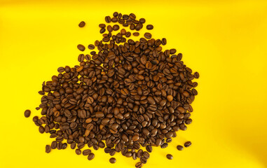 Natural roasted coffee beans on a sunny yellow background