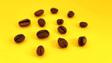 Natural roasted coffee beans on a sunny yellow background