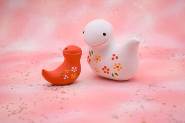 ピンク柄の背景に紅白の蛇の置き物　巳年　年賀素材　