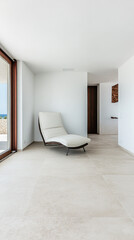 Fototapeta premium Modern interior of a serene coastal retreat featuring a sleek lounge chair and expansive windows for natural light