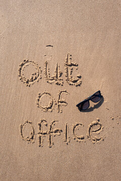 Out of Office inscription in the sand