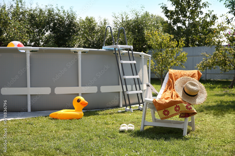 Canvas Prints Above ground swimming pool, folding chair, towel, inflatable ring and hat in backyard