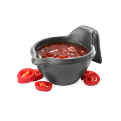 Hot chili sauce in gravy boat and pepper isolated on white