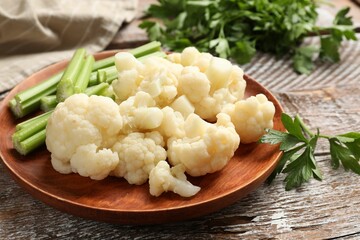 Tasty cauliflower with celery on wooden table, closeup