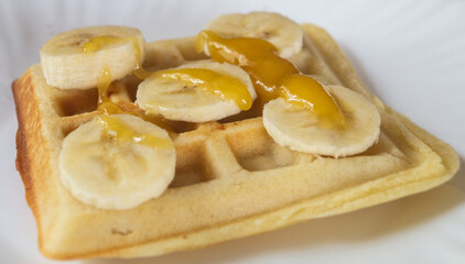 Belgian waffles with banana and honey on top. Belgian waffles with banana slices on top
