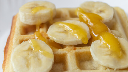 Belgian waffles with banana and honey on top. Belgian waffles with banana slices on top