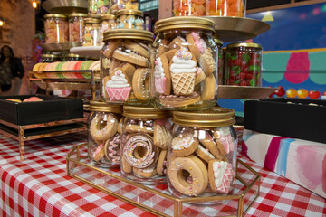 A jar of delicious sweet cookie biscuits in the shape of ice creams and donuts
