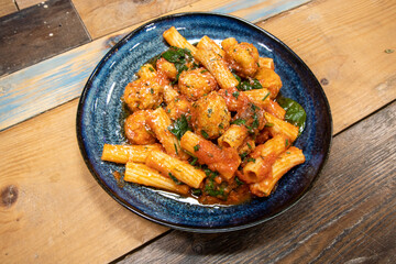 A delicious plate of pasta and meatballs on a wooden background