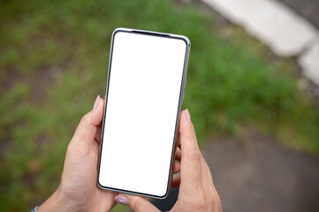 A smartphone mockup in a woman's hand, set against a blurred background of a green lawn.