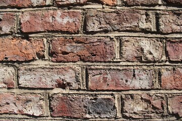 chaotic patterns and cracks in an old red brick wall