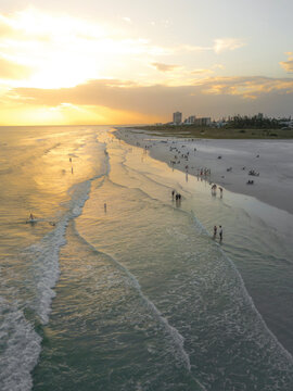 Aerial view of beautiful sunset over sandy beach with people and lifeguard house, Siesta Key, Florida, United States.