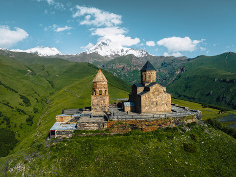 Aerial view of gergeti trinity church surrounded by majestic mountains and tranquil landscape, Stepantsminda, Georgia.