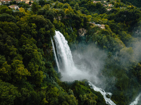 Aerial view of the breathtaking Marmore Falls surrounded by lush greenery and serene forest, Terni, Italy.