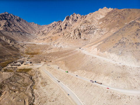 Aerial view of rugged mountains and a winding road through a scenic valley, Salang, Afghanistan.