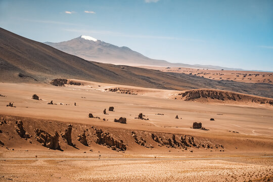 The stunning rock formations of Monjes de La Pacana (Pacana Monks) stand out in the 4000m high altiplano near San Pedro de Atacama, showcasing the area's natural beauty and geological importance.